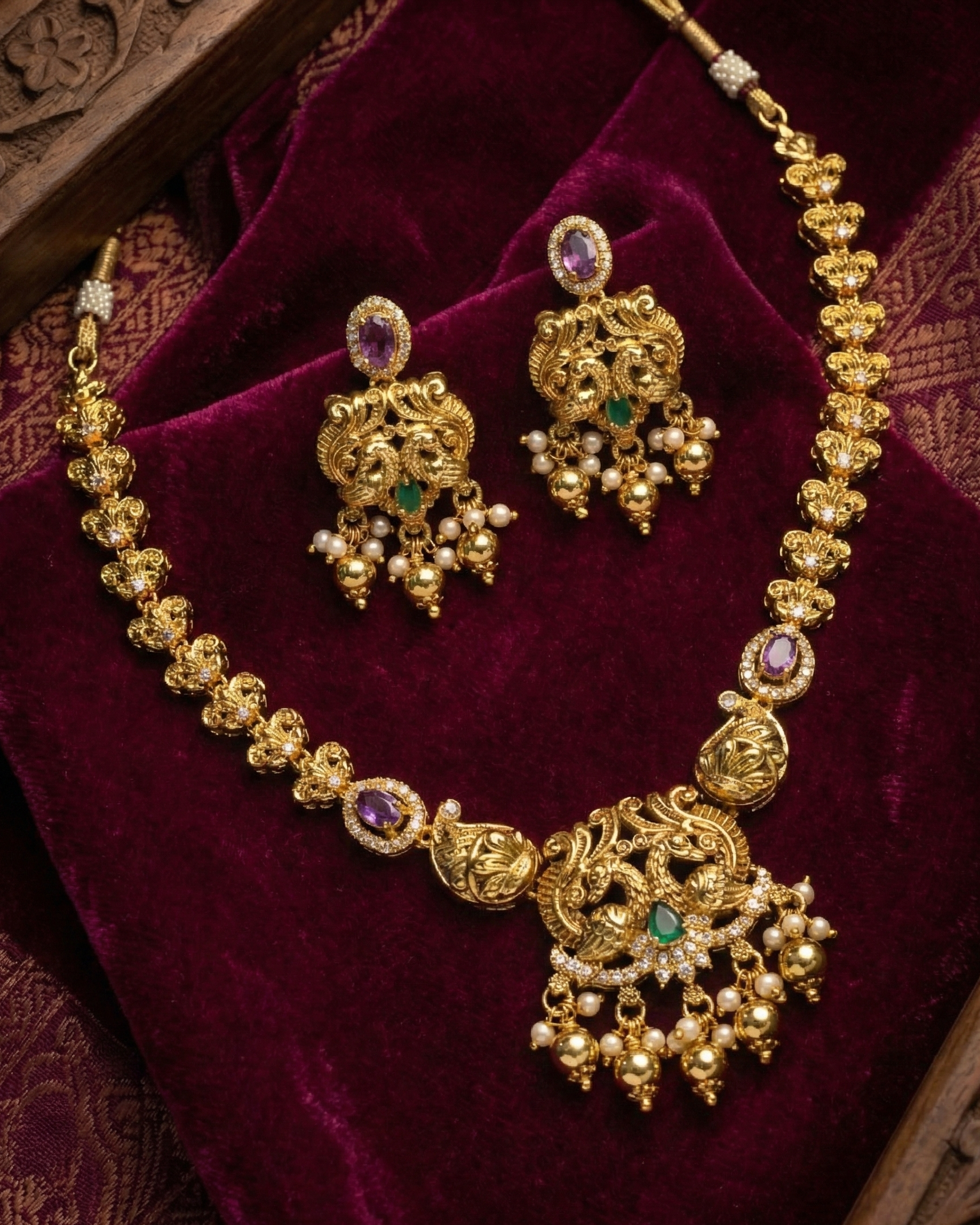 Gold necklace and earrings set on a purple velvet background suwarnikaa jewels www.suwarnikaajewels.com 